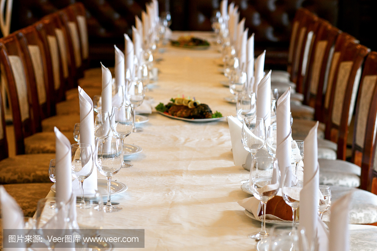 时尚的空酒杯和盘子,为客人设置在优雅的餐桌上的婚礼招待会